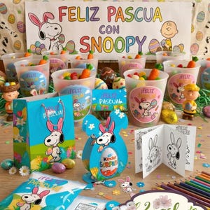 Puede incluir: Exhibición temática de Pascua con personajes de Snoopy. Incluye bolsas de regalo azules, cajas en forma de huevo y vasos llenos de caramelos y zanahorias. Una pancarta dice "Feliz Pascua con Snoopy". También hay libros para colorear y lápices de colores.