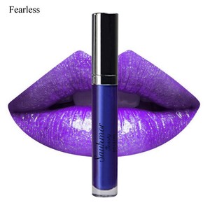 May include: A vibrant image showcases a tube of blue lip gloss against a backdrop of glossy, purple lips. The lip gloss tube has a silver cap and the text "Sauhmor Beauty HD Gloss" is printed on the tube. The word "Fearless" is in the upper left corner.