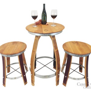 May include: A wine barrel table set with two stools. The table has a round top and a metal base. The stools are made from wine barrels and have a purple accent. The set is perfect for enjoying a glass of wine with friends.