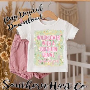 May include: A white t-shirt and pink shorts set for babies. The shirt features the text "WILDFLOWER WITH A SOUTHERN DRAWL" in pink and green, with floral accents. The words "southern girl" are also included. The words "Png Digital Download" and "Southern Hart Co" are also visible.