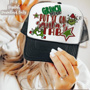 May include: A white trucker hat with a black mesh back. The front of the hat features a green Grinch character with the text "Grinch please put it on Santa's  " and a green star.