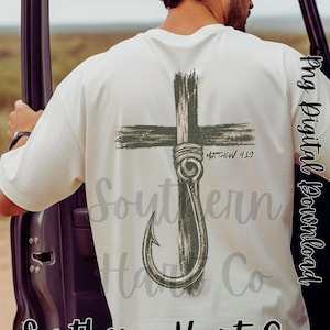 K&ouml;nnte beinhalten: Ein cremefarbenes Kurzarm-T-Shirt mit einer dunkelgr&uuml;nen Grafik auf der R&uuml;ckseite. Das Design zeigt ein Kreuz mit einem Angelhaken in der Mitte, begleitet von dem Text Matthew 4:19 in einer dunklen Schrift, mittig auf dem R&uuml;cken platziert.