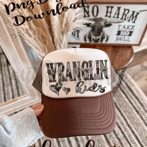 May include: A brown and white trucker hat with the text "WRANGLIN kids" in a camouflage design. The hat has a brown brim and a mesh back. The image also includes the text "Png Digital Download" and "southern hart co".