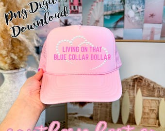 May include: Pink trucker hat with the text "LIVING ON THAT BLUE COLLAR DOLLAR" in a heart shape. The hat has a mesh back and a curved brim. The words "Png Digital Download" and "southern hart co" are also visible.