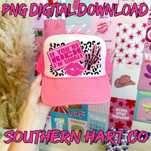 Peut inclure: Casquette de camionneur rose avec un filet blanc à l'arrière. La casquette est ornée d'un motif léopard rose et noir avec un signe de paix rose et un patch carré rose qui dit "Si tu es riche, je suis célibataire".