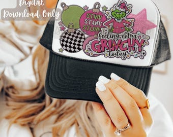 Könnte beinhalten: Eine schwarz-weiße Trucker-Kappe mit einem weißen Frontpanel, das ein pinkfarbenes und grünes Grinch-Design mit dem Text "STINK STANK STUN" und "feeling extra GRINCHY today" zeigt.