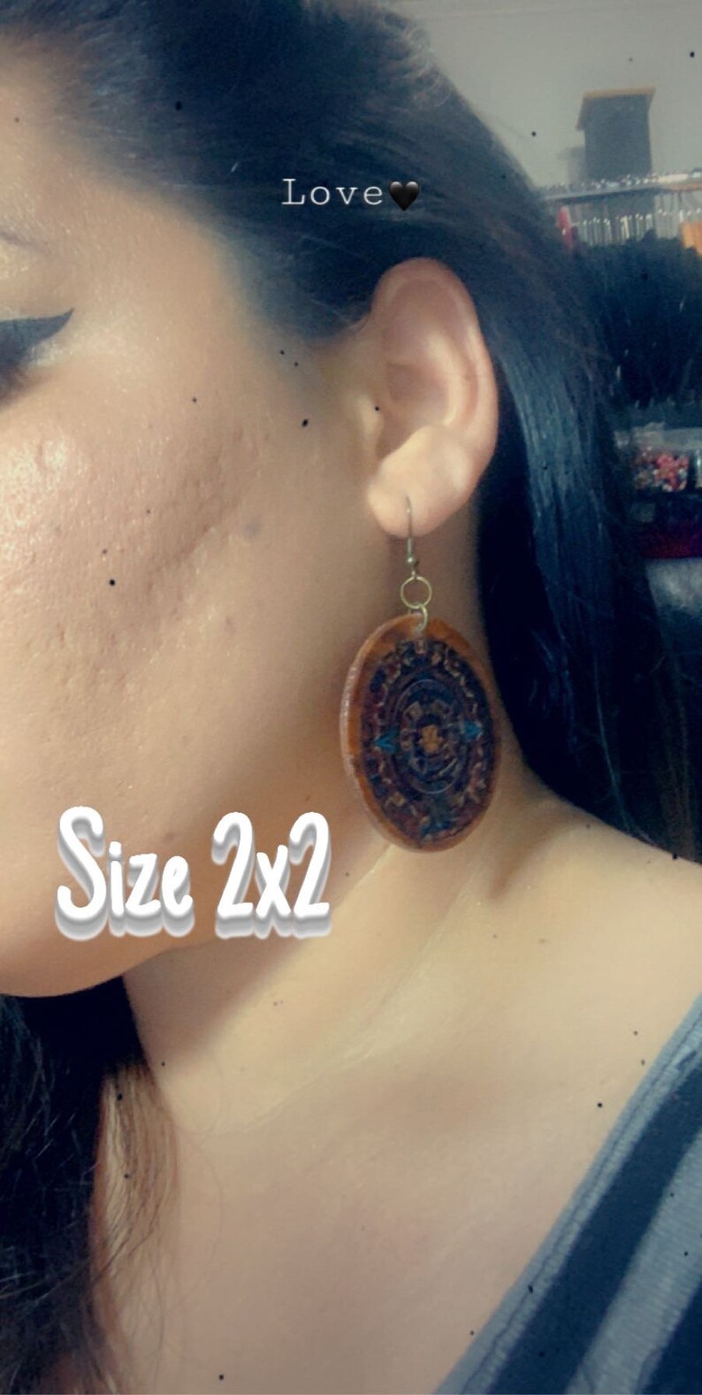 May include: A pair of brown leather earrings with a blue and gold geometric design. The earrings are 2 inches in diameter. The text "Love" and "Size 2x2" are visible in the image.