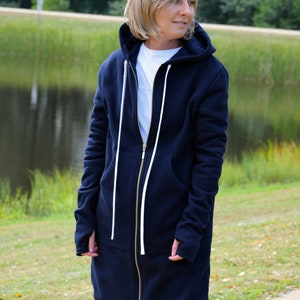 May include: A long navy blue hooded sweatshirt with a zipper closure and white drawstrings. The sweatshirt has a relaxed fit and is made of a soft, comfortable fabric.
