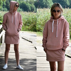 Pu&ograve; includere: Un set di felpa con cappuccio e gonna abbinata di colore rosa. La felpa ha un cappuccio con coulisse e una tasca a marsupio. La gonna &egrave; una minigonna con cintura.