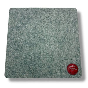 May include: A square, pale green felt pad with rounded corners. The felt has a textured appearance. A red circular sticker with white text that reads "TORONTO TYPEWRITERS COM" is in the lower right corner.