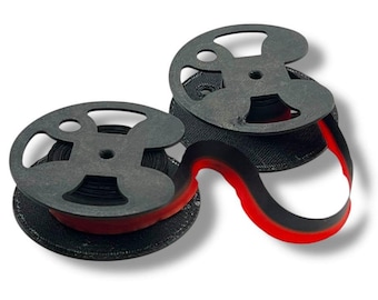 May include: Two black ribbon spools with a red accent. The spools have a unique, open design and are connected by a black and red ribbon. The spools are on a white background.