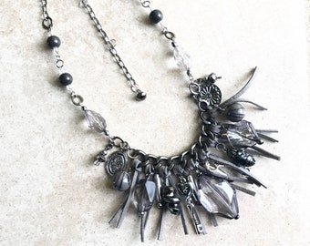 Suede fringe statement necklace featuring gray silver beads and key charms