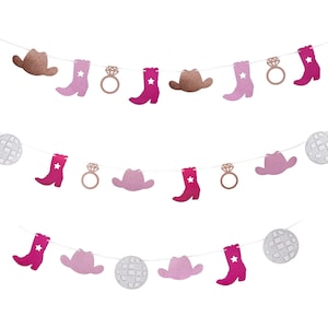 May include: A decorative banner with cut-out shapes of cowboy boots, hats, disco balls, and engagement rings. The boots and hats are pink and brown, with a star on the boots. The disco balls are silver, and the rings are rose gold.