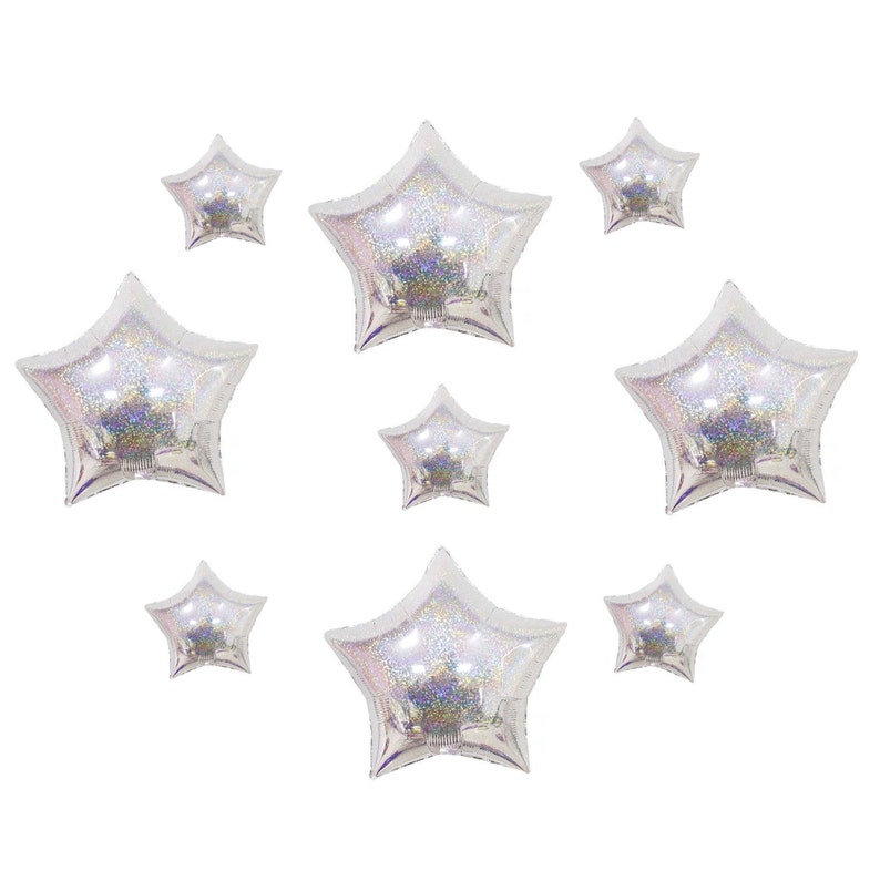 May include: A collection of eight star-shaped foil balloons in varying sizes. Each balloon features a translucent, iridescent finish with a holographic glitter effect that reflects light, creating a shimmering, multi-colored appearance.