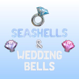 Könnte beinhalten: Folieballons mit der Aufschrift "SEASHELLS & WEDDING BELLS". Die Anordnung umfasst einen Diamantring-Ballon, zwei Muschel-Ballons und ein kaufmännisches Und. Die Ballons sind in Blau-, Silber- und Rosatönen gehalten.