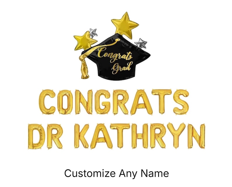 May include: A black graduation cap balloon with gold stars and the text Congrats Grad, accompanied by gold letter balloons spelling CONGRATS DR KATHRYN. The display includes a gold tassel and the text Customize Any Name at the bottom.