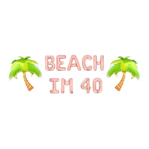 May include: Rose gold foil balloons spelling "BEACH IM 40" with two palm tree balloons on a white background. The palm trees have green fronds and orange trunks. Perfect for a beach-themed 40th birthday party.