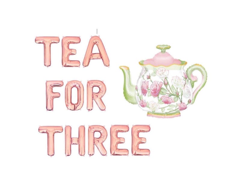 Puede incluir: Una tetera decorativa con un dise&ntilde;o floral y las palabras "TEA FOR THREE" en letras de globo de oro rosa. La tetera tiene detalles en rosa, verde y blanco.
