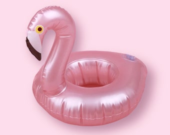 May include: Pink inflatable flamingo drink holder. The flamingo has a long neck, a white and brown beak, and a yellow eye. The drink holder is designed to float in water and has a circular opening to hold a beverage.