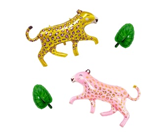 May include: Two inflatable leopard balloons, one gold and one pink, with brown spots. Two green leaf-shaped balloons are also included. The balloons are designed for party decorations and are set against a white background.