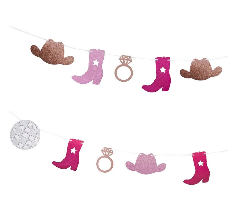 May include: A decorative banner with glittery cutouts of cowboy hats, boots with stars, a disco ball, and engagement rings. The colour palette includes shades of pink, rose gold, and brown, strung on white string.
