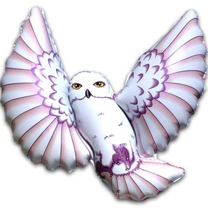 May include: A white and purple owl balloon with its wings spread out. The owl has yellow eyes and a pink beak.