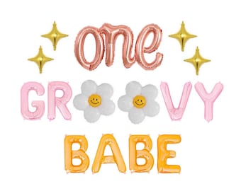 May include: A set of foil balloons featuring the text one GROOVY BABE in rose gold, light pink, and orange. The display includes two white daisy-shaped balloons with yellow smiley faces in the center and four small gold four-pointed star balloons.