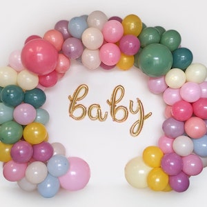 Puede incluir: Un arco de globos coloridos en tonos pastel, incluyendo rosa, verde, amarillo y azul. La palabra "baby" est&aacute; escrita con globos dorados en el centro del arco. Perfecto para un baby shower o una fiesta de revelaci&oacute;n de g&eacute;nero.