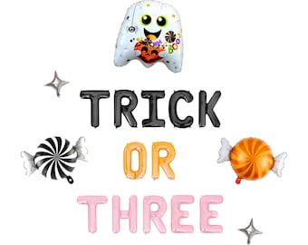 May include: A set of foil balloons featuring a white ghost holding a pumpkin, black letter balloons spelling TRICK, orange letter balloons spelling OR, and light pink letter balloons spelling THREE, with two round candy balloons and two silver stars.