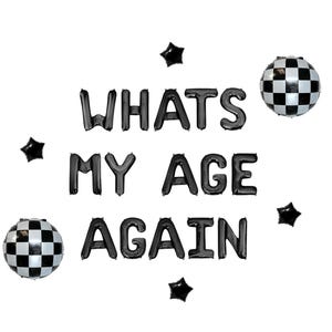 May include: Black balloon letters spell "WHAT'S MY AGE AGAIN" with star and checkered ball accents. A fun and playful decoration for a birthday party or event.