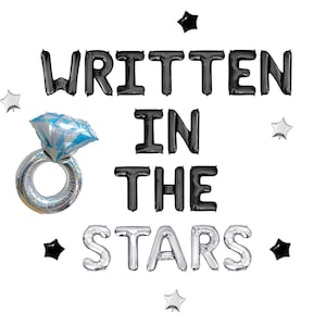May include: A collection of foil balloons spelling out "WRITTEN IN THE STARS." The balloons are black and silver, with a diamond ring balloon and star-shaped balloons. Perfect for a wedding or engagement celebration.
