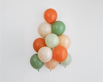 May include: A cluster of colorful balloons in shades of orange, green, cream, and peach. The balloons are arranged in a cascading pattern, creating a festive and celebratory look. Perfect for a birthday or special event.