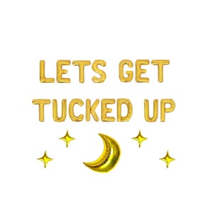May include: Gold foil balloon letters spelling "LETS GET TUCKED UP" with a gold crescent moon and four gold star-shaped balloons. The balloons are arranged on a white background.