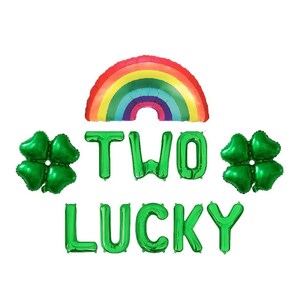 May include: Green foil balloons spelling out "TWO LUCKY" with two green four-leaf clover balloons and a rainbow balloon.