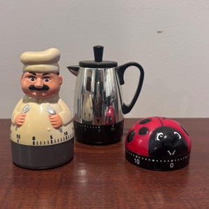 May include: A white ceramic mug with a black handle and the text "But First, Coffee" in a black, bold font. The mug is on a white surface.