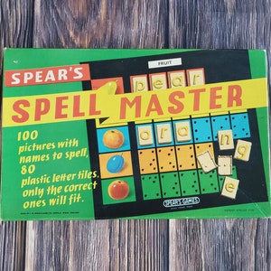 Puede incluir: Una caja de juego de mesa verde y amarilla con el título "SPELL MASTER" y una imagen de fruta. La caja dice "100 imágenes con nombres para deletrear, 80 fichas de letras de plástico. Solo las correctas encajan."