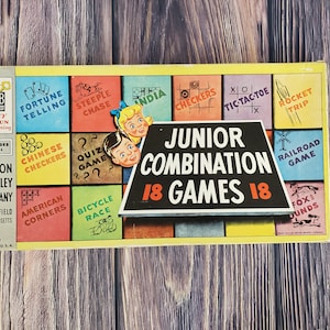 May include: A vintage Milton Bradley game box featuring a colorful illustration of 18 different games for children. The box is labeled "Junior Combination 18 Games 18".
