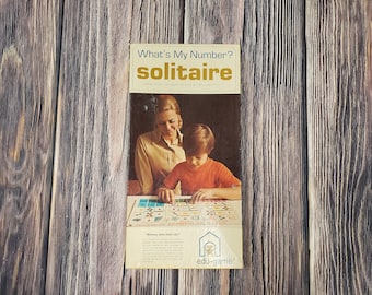 May include: A vintage board game box featuring a mother and child playing "What's My Number? Solitaire". The box is yellow with blue and red accents. The game is for children aged 6 to 12.