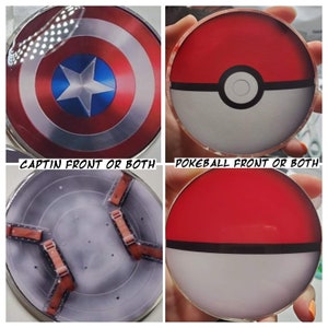 May include: Two round, flat, decorative coasters. One is red, white, and blue with a star in the center and the text "CAPTIN FRONT OR BOTH". The other is red, white, and black with a circle in the center and the text "POKEBALL FRONT OR BOTH".