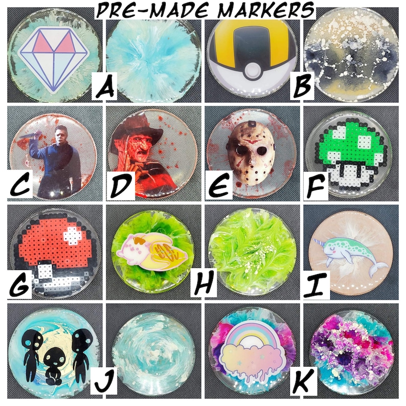 May include: A set of 12 pre-made resin markers with various designs. The designs include a diamond, a blue swirl, a Pokeball, a black and white swirl, a man with a knife, a man with a mask, a green mushroom, a red mushroom, a cartoon character, a green swirl, a narwhal, a group of aliens, a blue swirl, a rainbow cloud, and a purple and pink swirl.