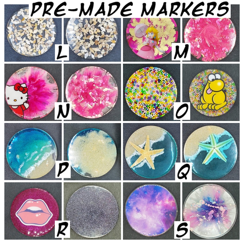 May include: Nine round resin coasters with various designs. The coasters feature a variety of themes, including seashells, cartoon characters, and abstract patterns. The coasters are labeled with letters L through S.