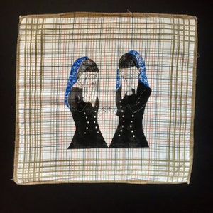 May include: Two figures in black dresses with blue and white head coverings are depicted on a white and brown plaid fabric. The figures are facing each other and have their hands covering their eyes.