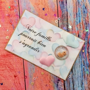 Carte annonce grossesse avec petit fœtus dans son enveloppe et sa petite fleur