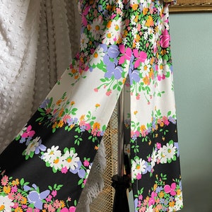 Puede incluir: Una falda de estampado floral blanco y negro con una abertura lateral. La falda tiene un fondo blanco con detalles florales negros y un fondo negro con detalles florales blancos.