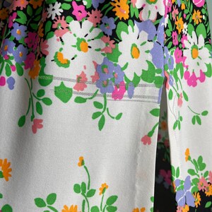 Puede incluir: Una tela blanca con un estampado floral en blanco y negro. La tela tiene una costura en el lateral y una peque&ntilde;a abertura en la parte inferior.
