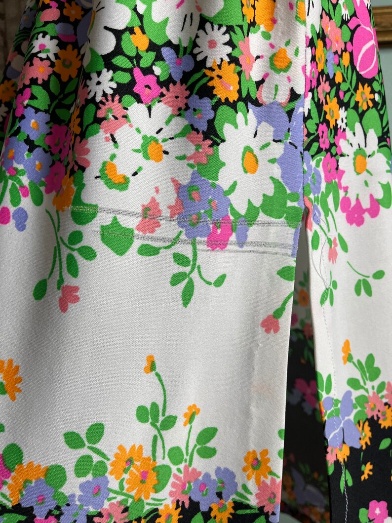 Puede incluir: Una tela blanca con un estampado floral en blanco y negro. La tela tiene una costura en el lateral y una peque&ntilde;a abertura en la parte inferior.