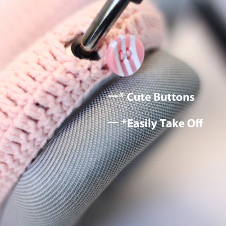 Pu&ograve; includere: Primo piano di una copertura per cuffie in crochet rosa con simpatici bottoni a righe rosa e bianchi. Il testo "*Cute Buttons" e "*Easily Take Off" &egrave; visibile nell'immagine.