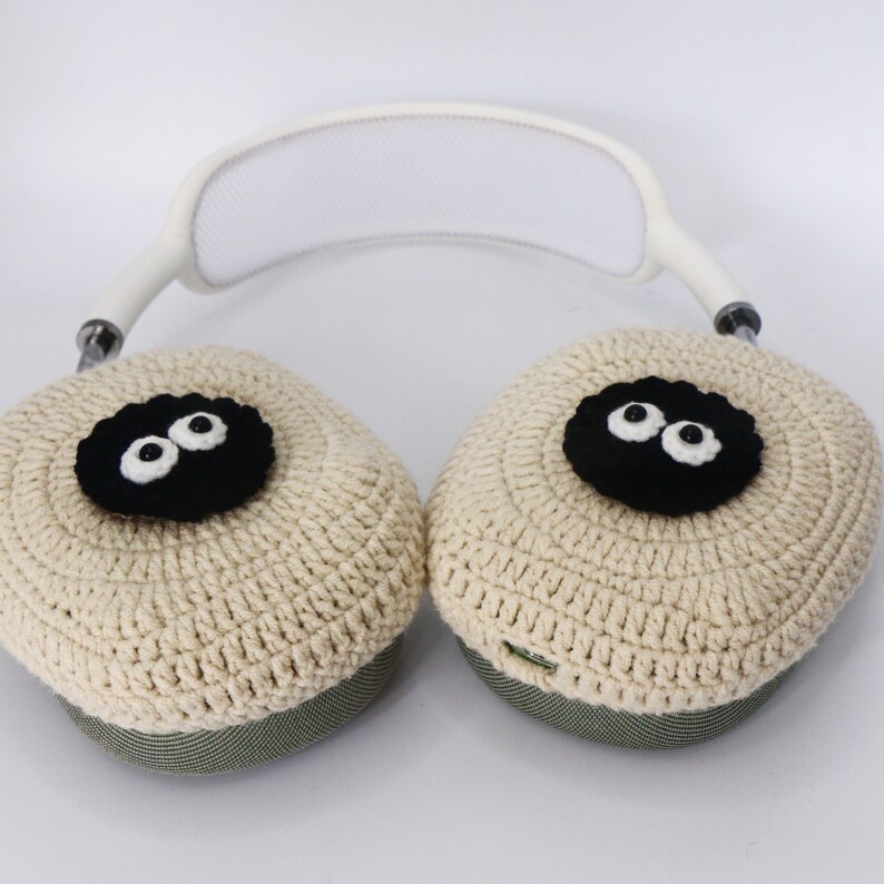 Pu&ograve; includere: Copri auricolari in crochet beige con occhi in feltro nero. Le cover sono attaccate a una fascia bianca.