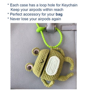 K&ouml;nnte beinhalten: Ein gr&uuml;nes, geh&auml;keltes Frosch-Airpods-Etui mit einem hellgr&uuml;nen Riemen. Das Etui hat ein Schlaufenloch f&uuml;r einen Schl&uuml;sselanh&auml;nger. Der Text auf dem Bild lautet: "Jede H&uuml;lle hat ein Schlaufenloch f&uuml;r einen Schl&uuml;sselanh&auml;nger, Behalten Sie Ihre Airpods in Reichweite, Verlieren Sie Ihre Airpods nie wieder."
