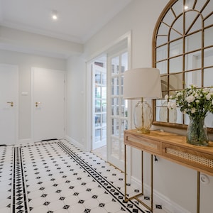 Consola con trenzado vienés de ratán natural sobre una estructura metálica dorada de estilo bohemio, tocador moderno con cajones, roble natural